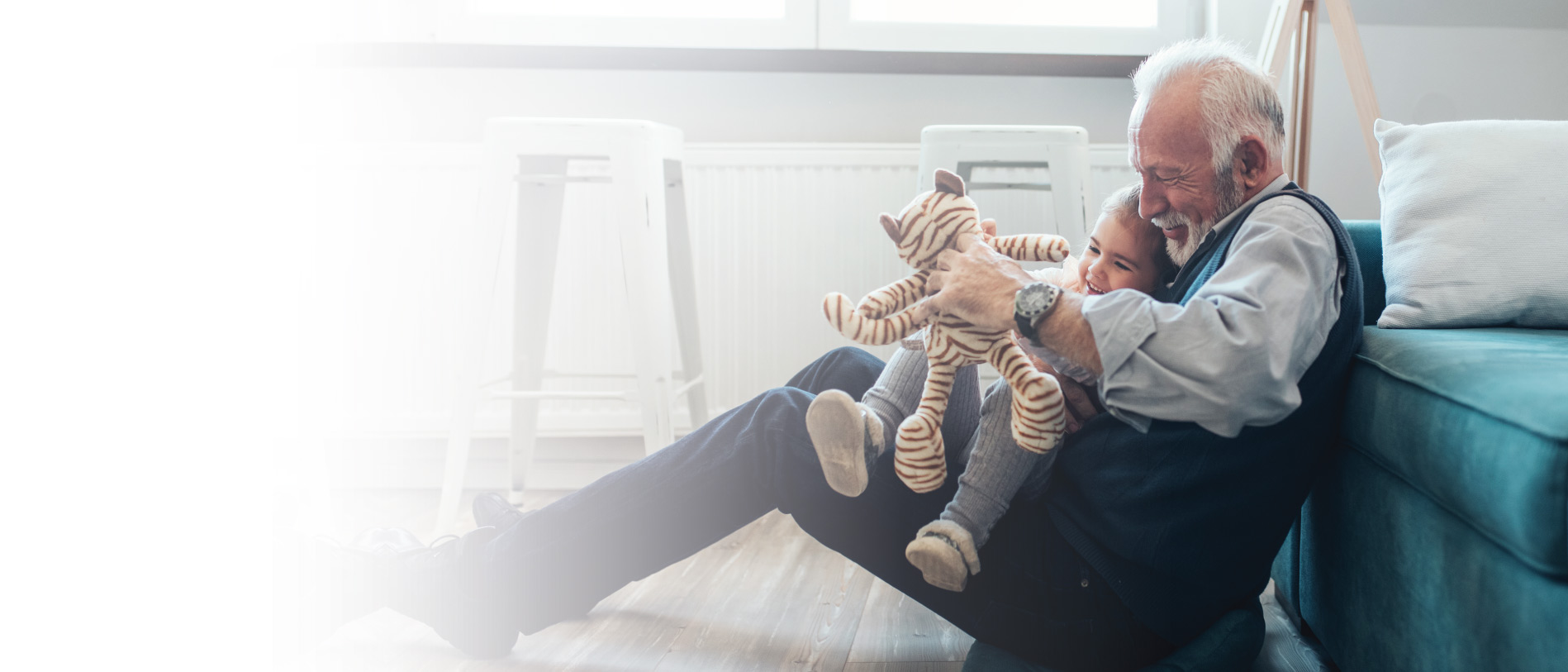 Grandpa with grandkid playing with a stuffed tiger